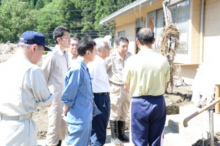 グループホーム「楽ん楽ん」の献花台の前で説明を聞く視察団